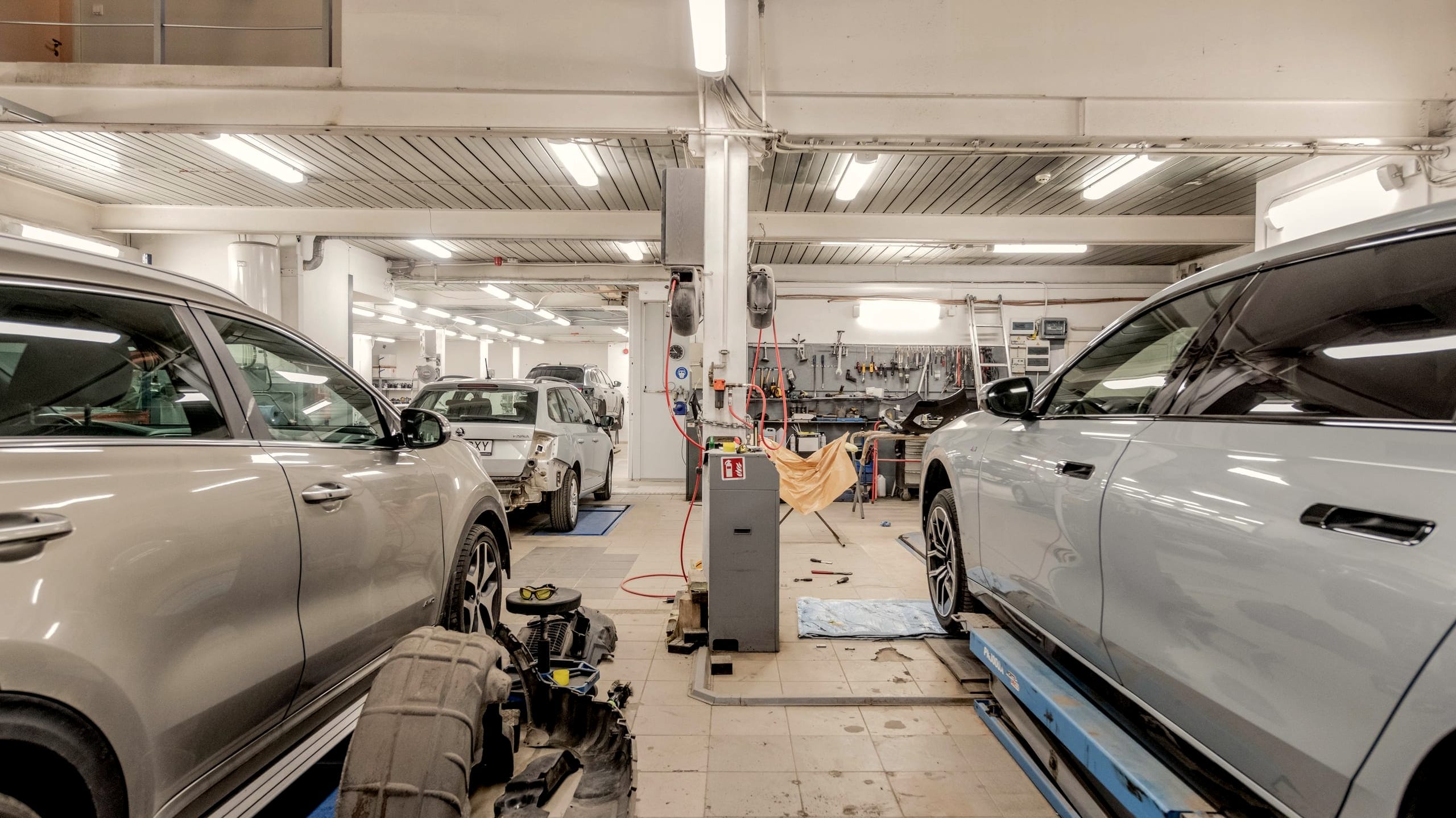 Auto uniesione na podnośniku dwukolumnowym w hali warsztatowej EMKACAR-SERVICE